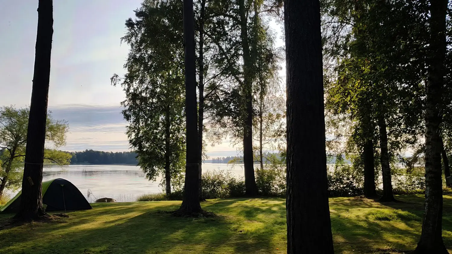 Teltta rauhallisella järvenrantaleirillä
